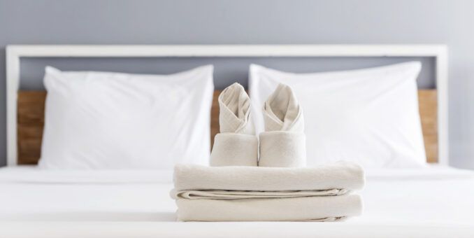 folded white towel in a hotel bedroom